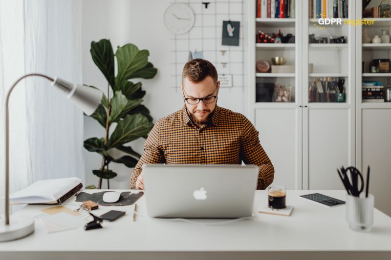 businessman working on a laptop in a home office, preparing documents, representing small business GDPR compliance efforts