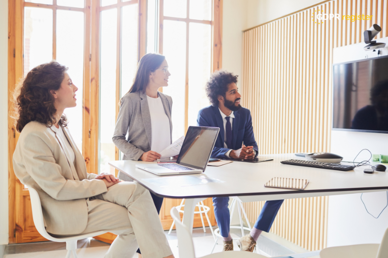 "Professional team in a conference room discussing GDPR compliance, with a laptop and presentation screen, illustrating collaborative data mapping efforts.